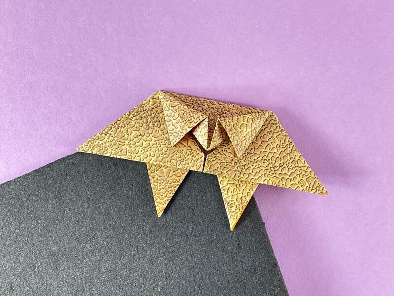 Origami Monster-Lesezeichen aus goldbraunem Papier mit Schuppenstruktur