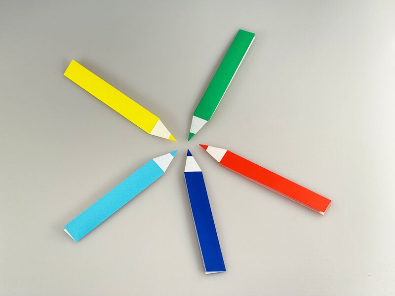 Fünf bunte Origami Stifte in den Farben grün, rot, blau, hellblau und gelb gefaltet aus Origami Papier